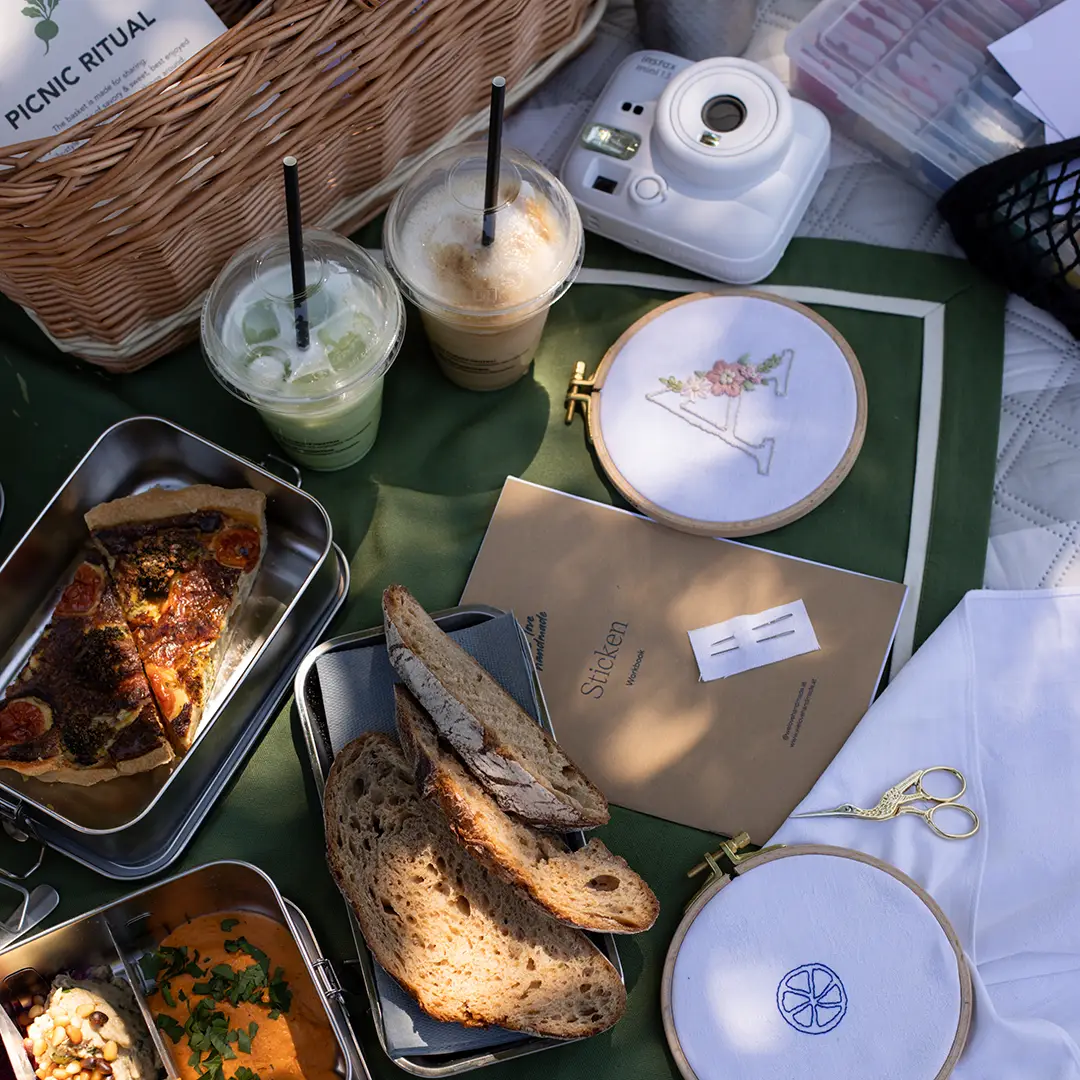 Picnic Ritual Karte von SiL neben Kaffee, Matcha und einem bestickten Buchstaben A im Stickrahmen